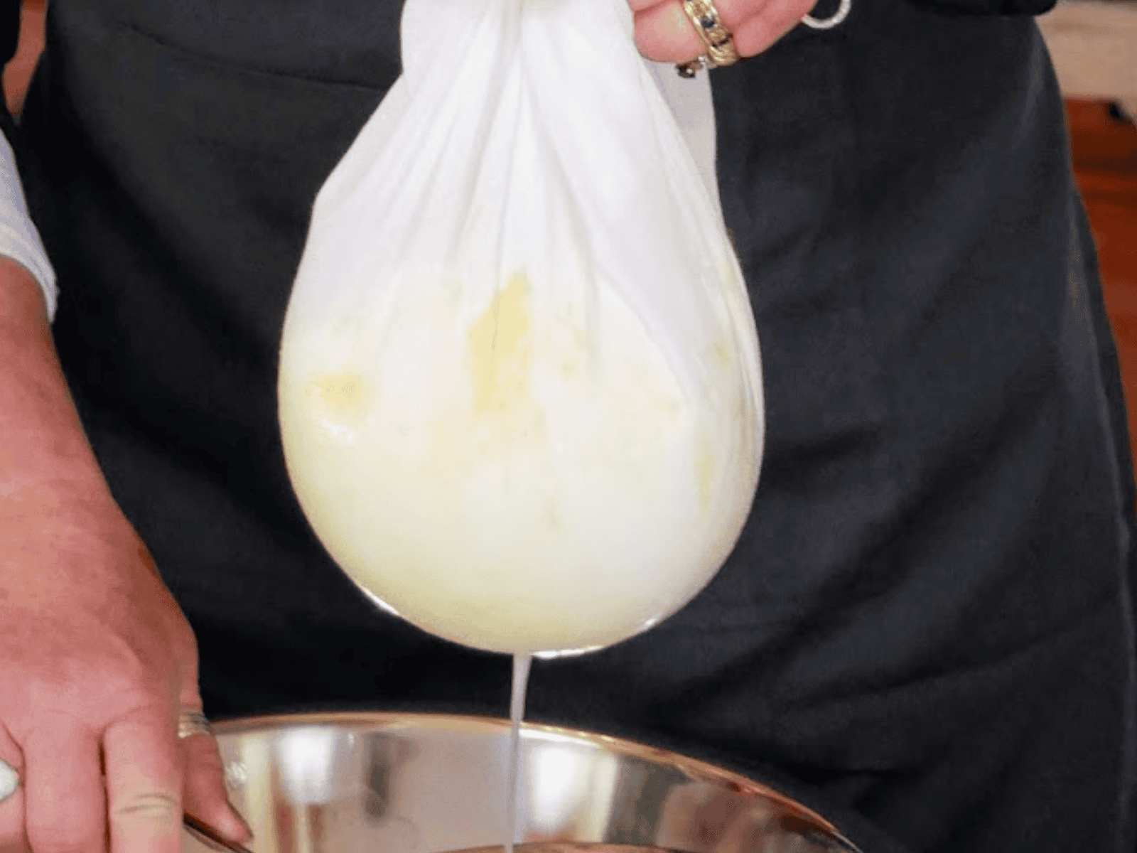 Draining whey from the curd in an Adelaide cheesemaking class