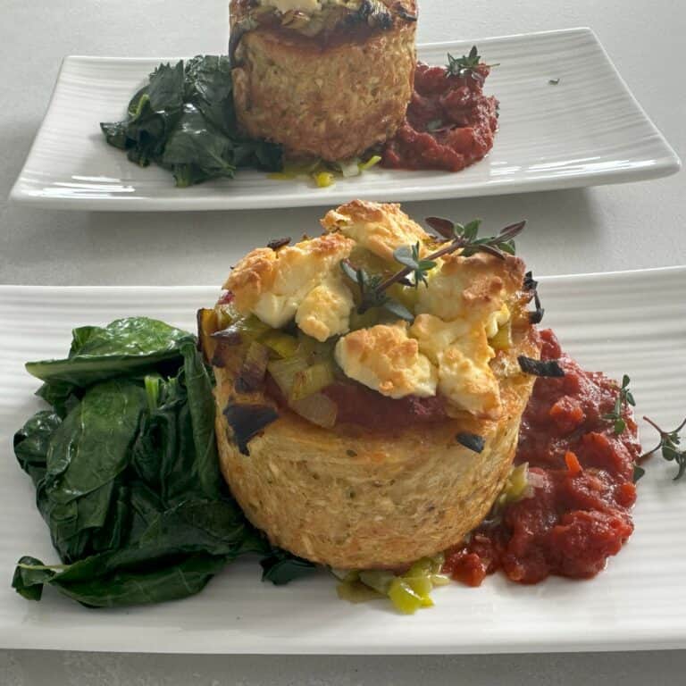 Creamy cheese stuffed souffle wrapped in a flaky pastry with fresh herbs and vegetable sides.