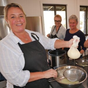 Jackie holding up the cheese in cheese cloth