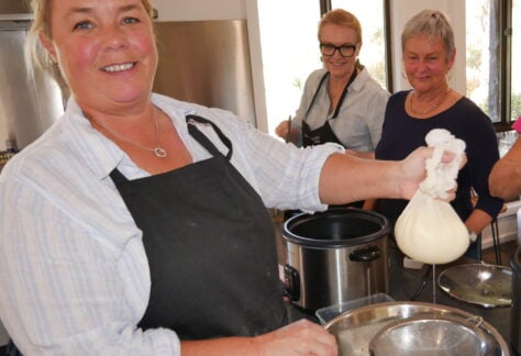 Jackie holding up the cheese in cheese cloth