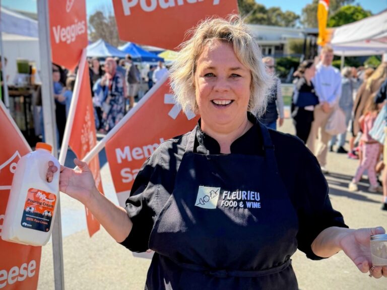 Jackie at the farmers market holding a bottle of Fleurieu Milk Company pouring cream