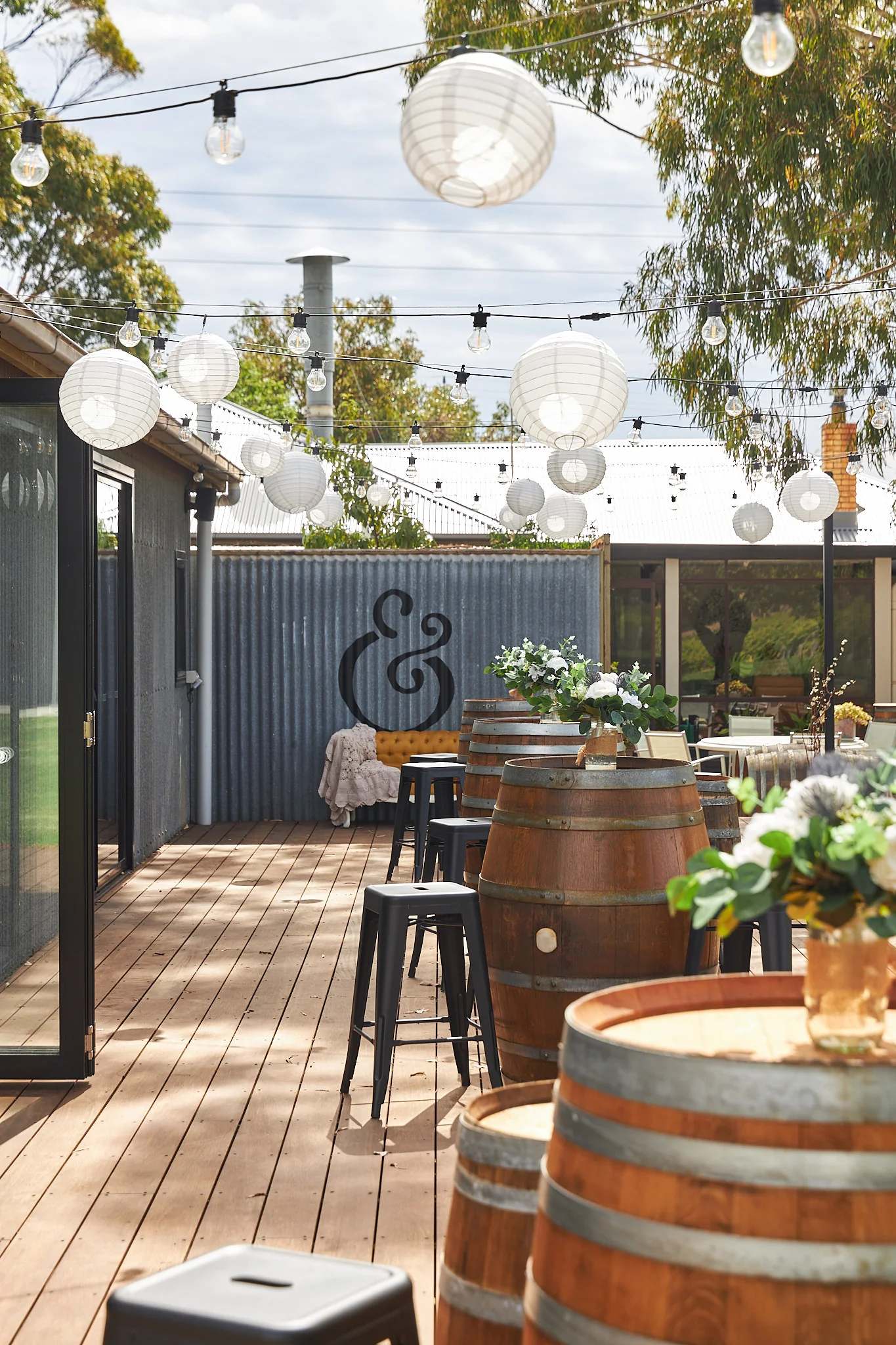 The Hastwell and Lightfoot cellar door deck at McLaren Vale set with wine barrels and festoon lights