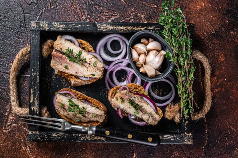 Fresh seafood canapes with garlic, herbs, and sliced onions on rustic bread. Perfect for Fleurieu Food & Wine experiences.