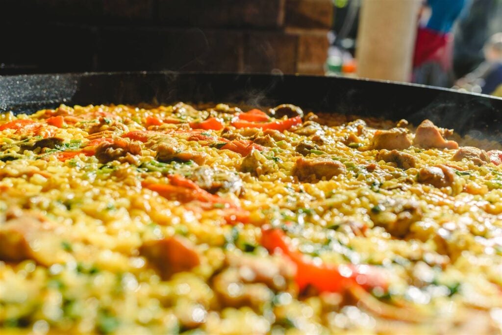 A close-up of traditional paella rice with peppers and seafood